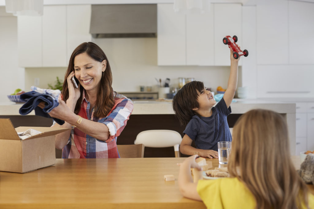 Picture of mother on phone while at the table with children