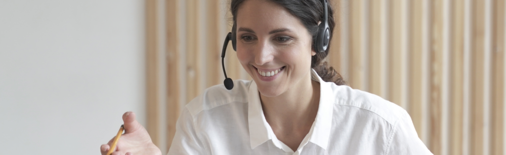 Image of a woman smiling and talking on a headset