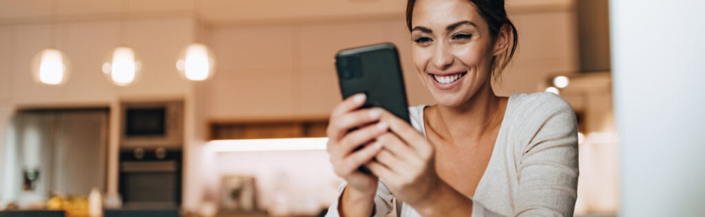 A woman on her phone who is happy so will not affect the company's CSAT score